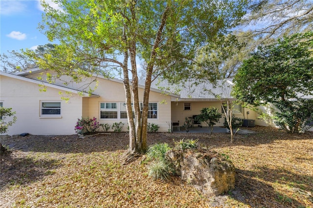 back of property with a patio and central AC