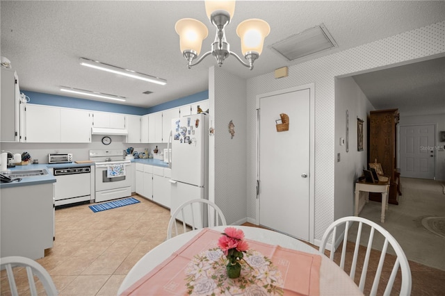 dining space featuring light tile patterned flooring, a toaster, a textured ceiling, and an inviting chandelier