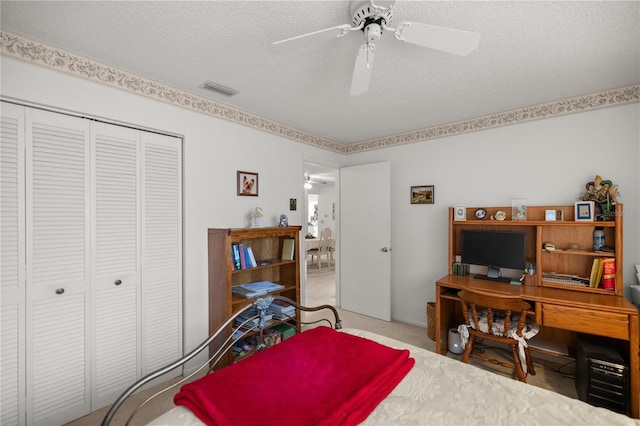 bedroom with visible vents, carpet floors, ceiling fan, a closet, and a textured ceiling