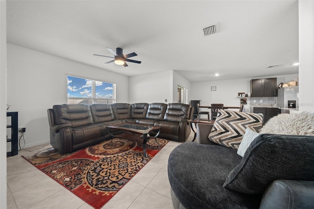 living area with light tile patterned floors, baseboards, visible vents, and a ceiling fan