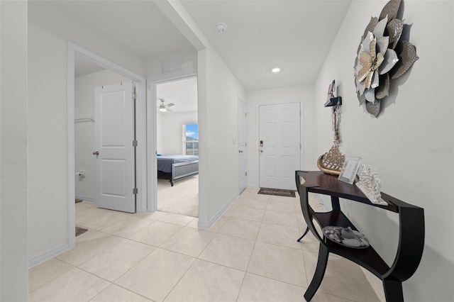 hallway featuring recessed lighting, light tile patterned flooring, and baseboards