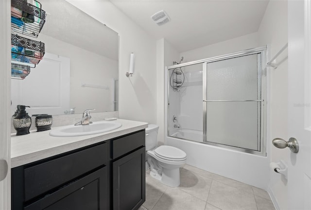 full bathroom featuring toilet, vanity, visible vents, combined bath / shower with glass door, and tile patterned floors