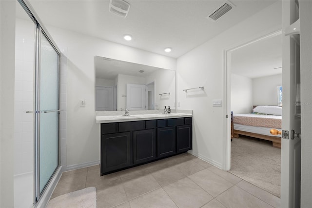 ensuite bathroom with a stall shower, visible vents, a sink, and ensuite bathroom