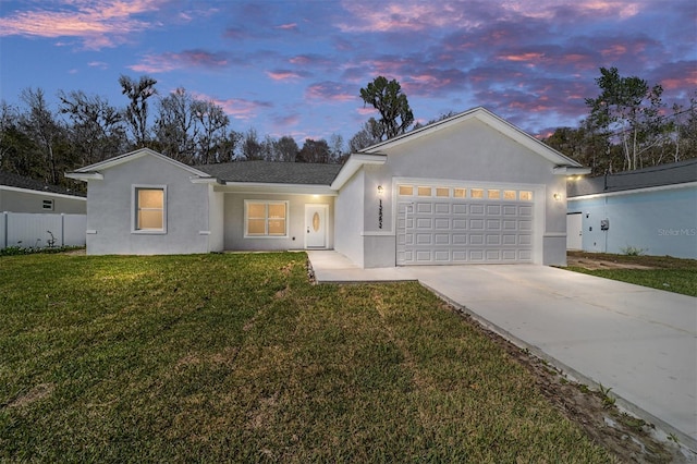 ranch-style home featuring an attached garage, a front yard, concrete driveway, and stucco siding