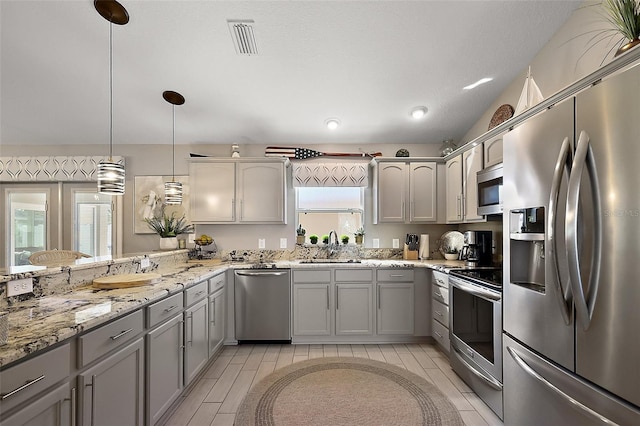 kitchen featuring stainless steel appliances, gray cabinets, visible vents, a sink, and light stone countertops