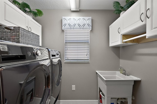 laundry room with cabinet space, washer and clothes dryer, and a sink