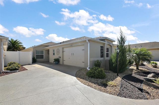 ranch-style home with a garage, concrete driveway, fence, and stucco siding