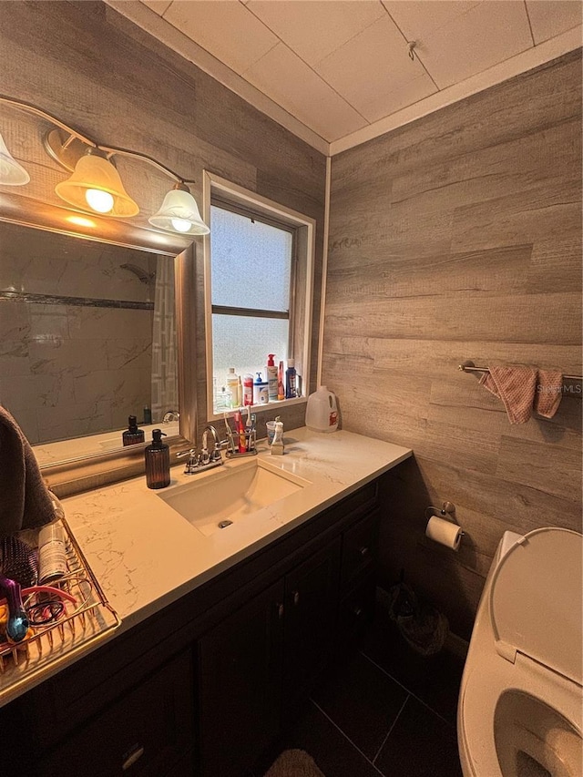 bathroom with wood walls, vanity, a shower, and toilet