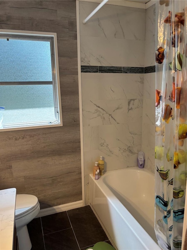 bathroom featuring tile patterned floors, toilet, and shower / bath combo with shower curtain