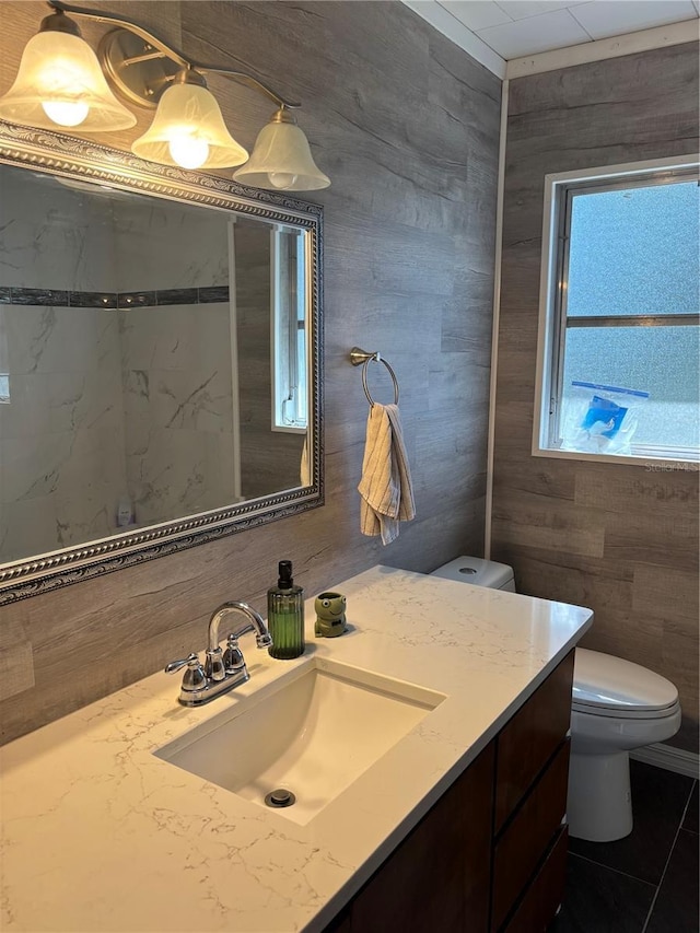 bathroom featuring vanity, tile walls, and toilet