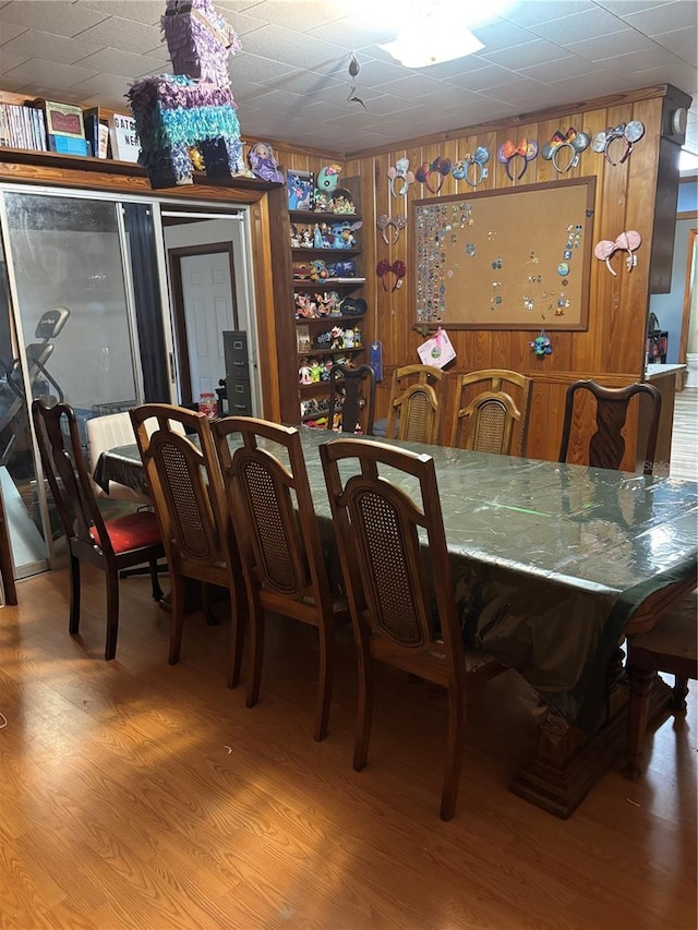 dining space featuring wooden walls and wood finished floors