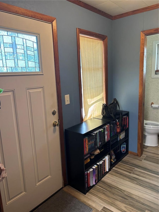 foyer featuring crown molding and wood finished floors