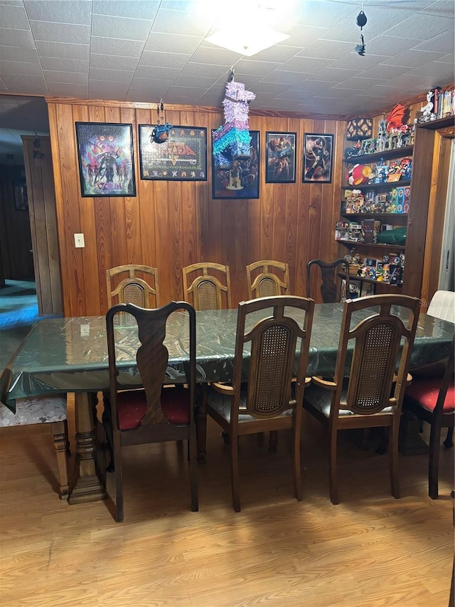 dining room with wood finished floors and wood walls