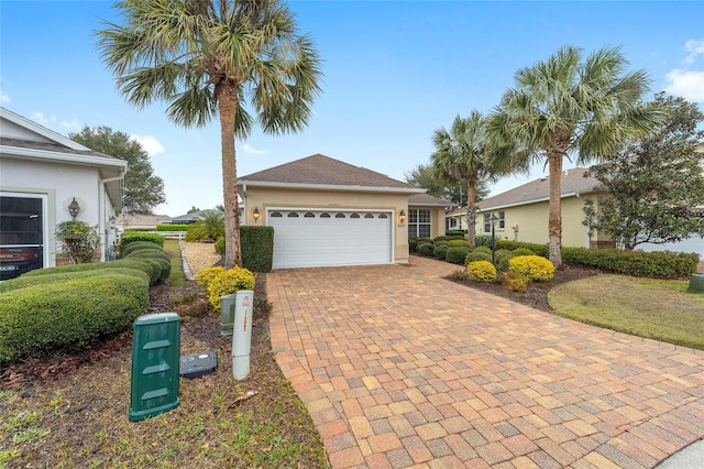 ranch-style house featuring decorative driveway, an attached garage, and stucco siding