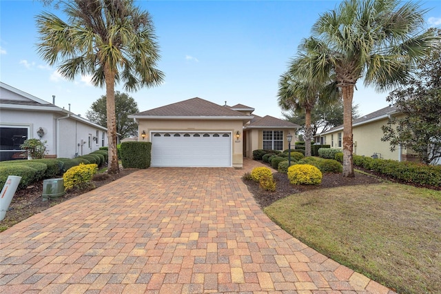 ranch-style home with a garage, decorative driveway, and stucco siding