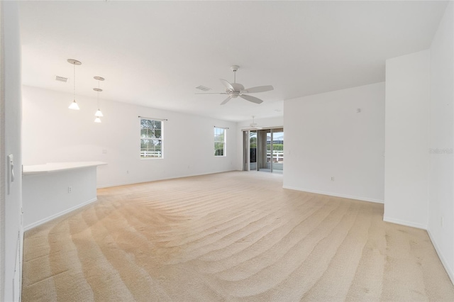 unfurnished room featuring light carpet, ceiling fan, visible vents, and baseboards