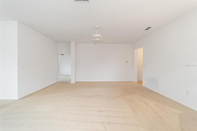 spare room featuring a ceiling fan, visible vents, and light carpet