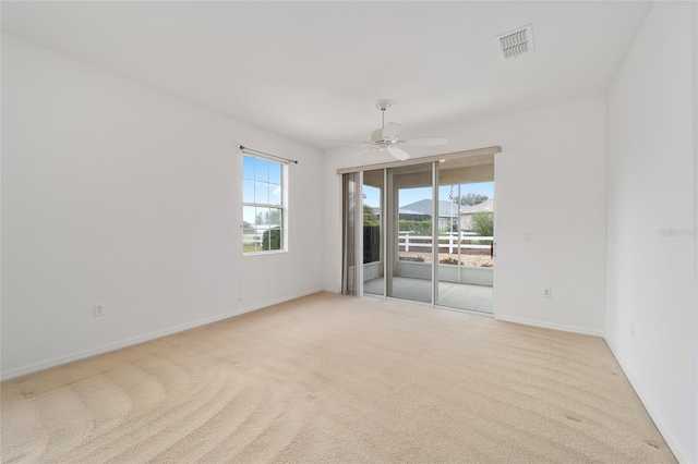 unfurnished room featuring light carpet, ceiling fan, visible vents, and baseboards