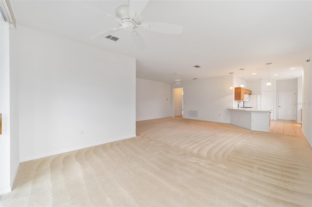 unfurnished living room with light carpet, ceiling fan, and visible vents