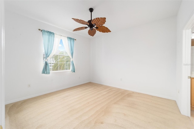 empty room with ceiling fan, baseboards, and light colored carpet