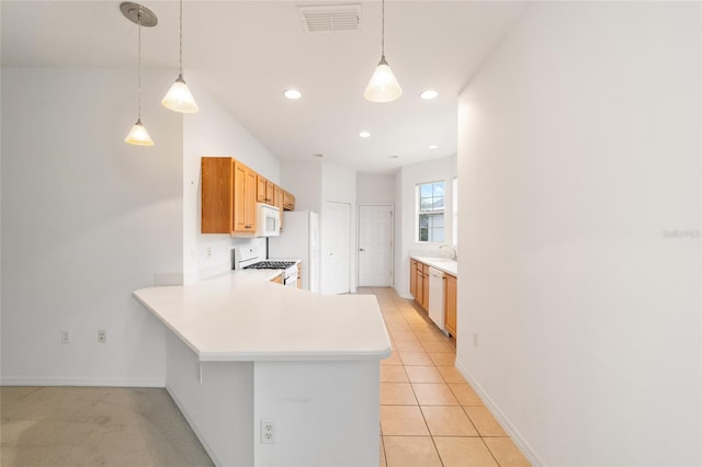 kitchen with a peninsula, white appliances, light countertops, and decorative light fixtures