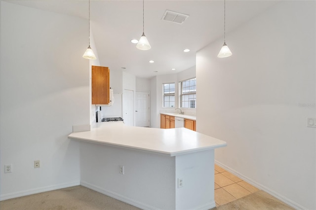 kitchen with a peninsula, visible vents, light countertops, dishwasher, and pendant lighting