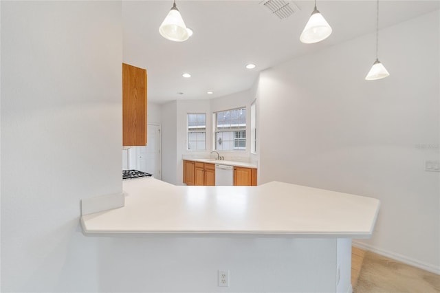 kitchen featuring dishwasher, light countertops, a peninsula, and visible vents