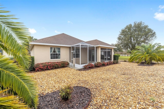 view of front of house with a lanai, a shingled roof, and stucco siding