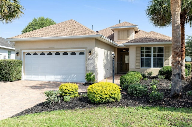 8669 SW 88th Loop, Ocala, FL 34481 - view of front of home featuring stucco siding, an attached garage, driveway, and roof with shingles