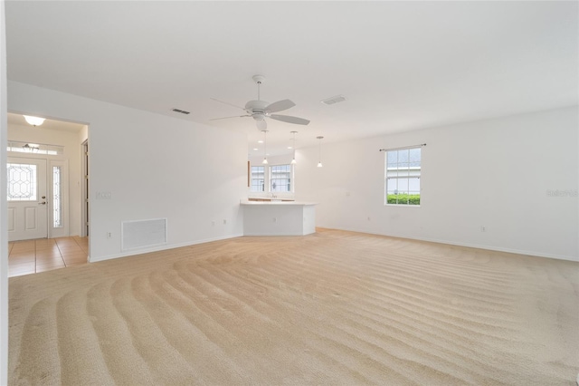 8669 SW 88th Loop, Ocala, FL 34481 - unfurnished living room featuring light colored carpet, a ceiling fan, and baseboards