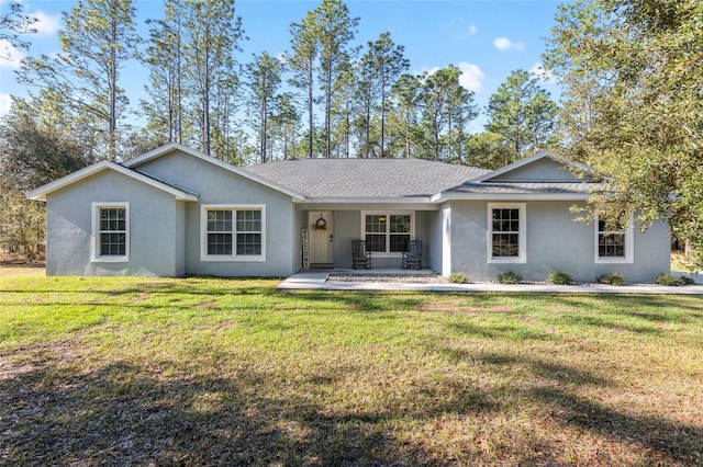 single story home with a shingled roof, a front lawn, and stucco siding