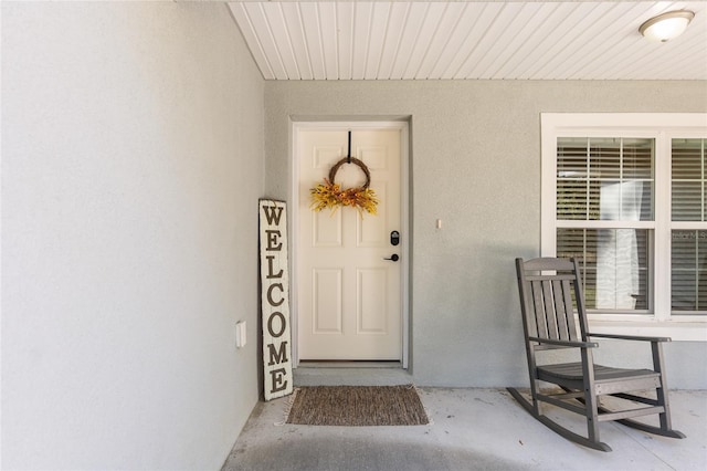 doorway to property featuring stucco siding