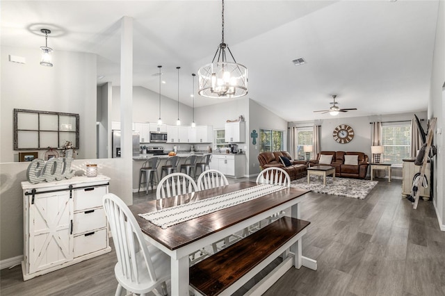 dining room featuring lofted ceiling, dark wood-style flooring, visible vents, baseboards, and a ceiling fan