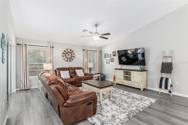 living area featuring a ceiling fan, baseboards, visible vents, and wood finished floors