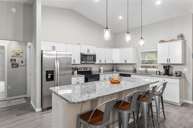 kitchen featuring white cabinetry, a kitchen island, appliances with stainless steel finishes, and a sink