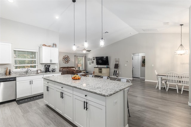 kitchen featuring open floor plan, a center island, stainless steel dishwasher, light wood-style floors, and a sink