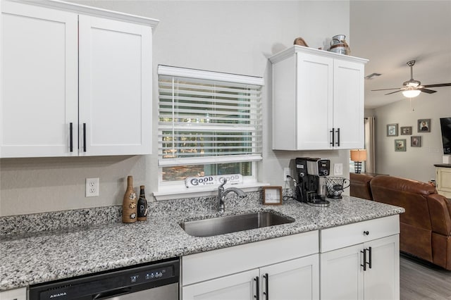 kitchen featuring open floor plan, white cabinetry, a sink, and dishwashing machine