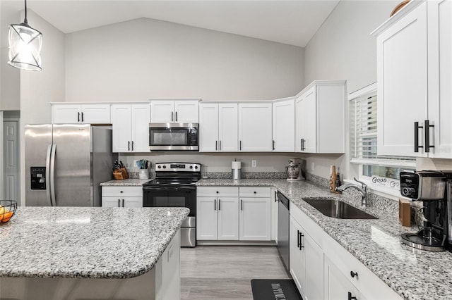 kitchen featuring a sink, white cabinetry, vaulted ceiling, appliances with stainless steel finishes, and pendant lighting