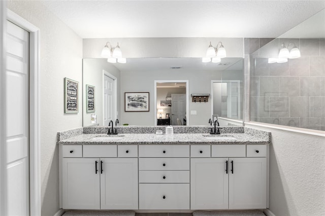 full bathroom with a walk in shower, double vanity, a sink, and visible vents