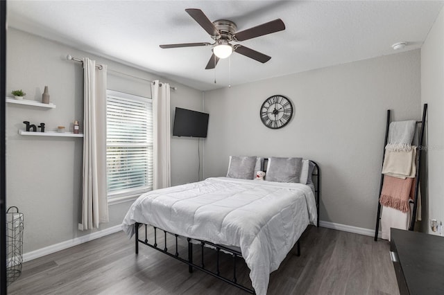 bedroom featuring a ceiling fan, baseboards, and wood finished floors