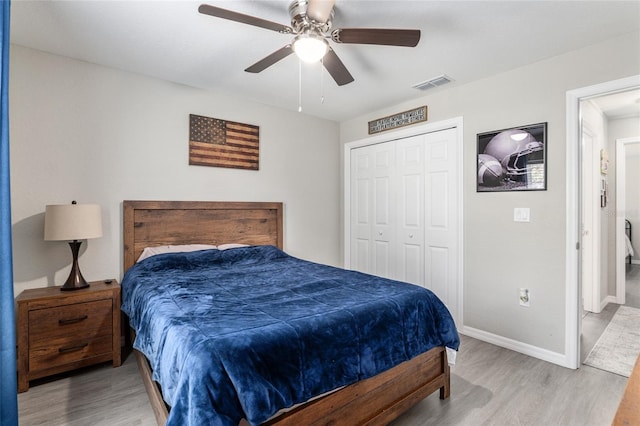 bedroom with baseboards, visible vents, ceiling fan, light wood-type flooring, and a closet