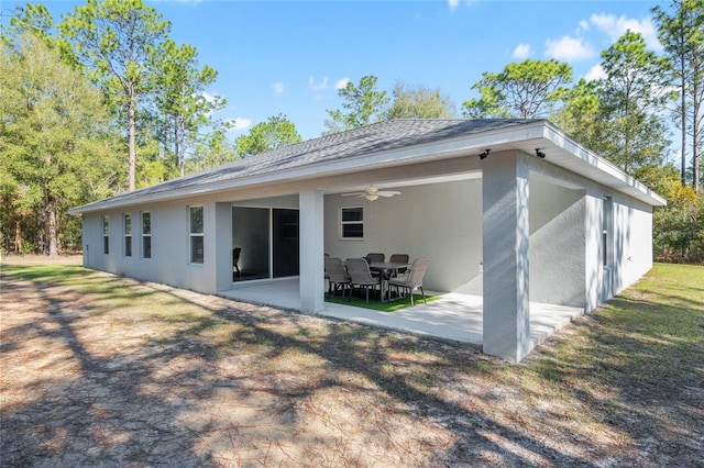 rear view of house featuring a patio, roof with shingles, a ceiling fan, and stucco siding