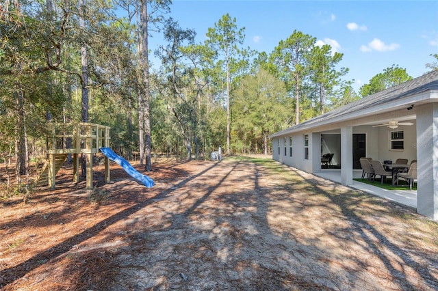 view of yard with a ceiling fan, a playground, and a patio