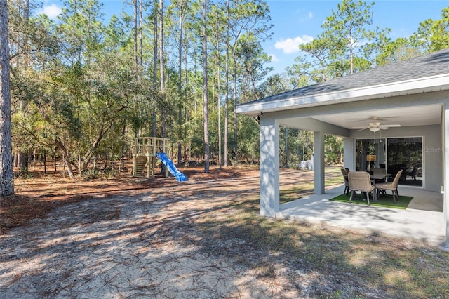 view of yard featuring a patio area, a playground, and ceiling fan