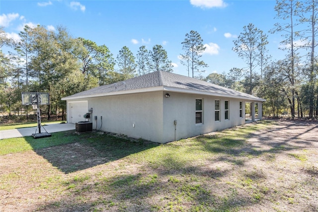 view of home's exterior featuring roof with shingles, a lawn, and stucco siding