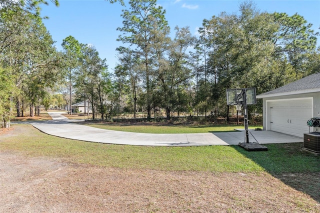 view of yard featuring a garage and cooling unit