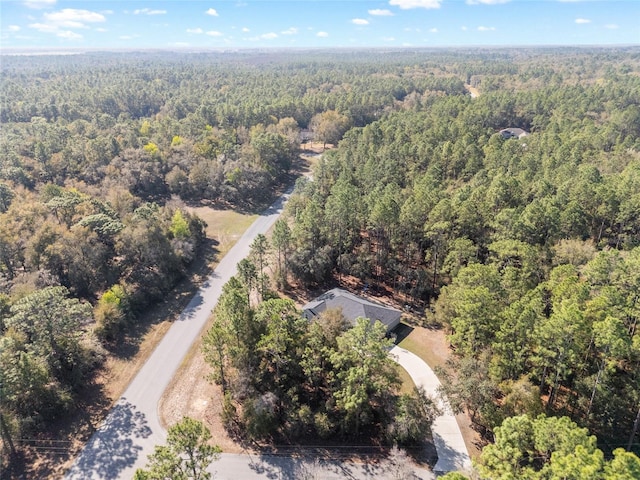 drone / aerial view with a wooded view