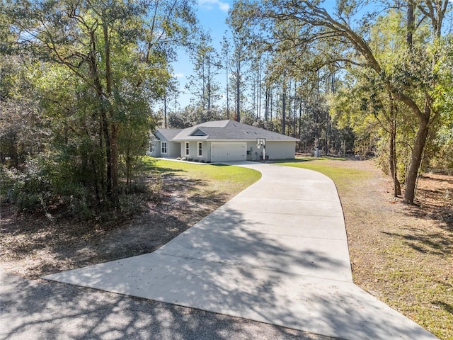 single story home featuring a garage, a front yard, and concrete driveway