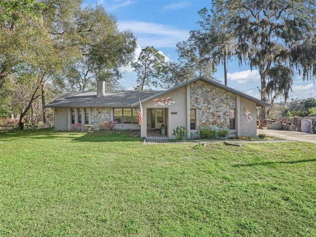 view of front of house featuring stone siding, a chimney, stucco siding, and a front yard