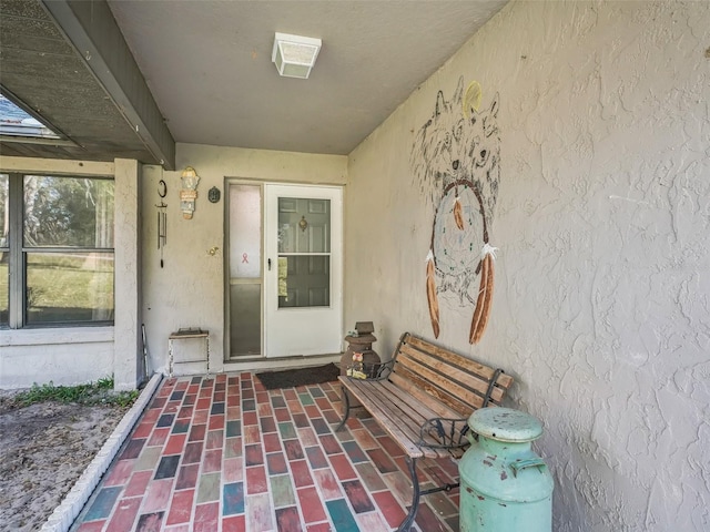 view of exterior entry with a patio